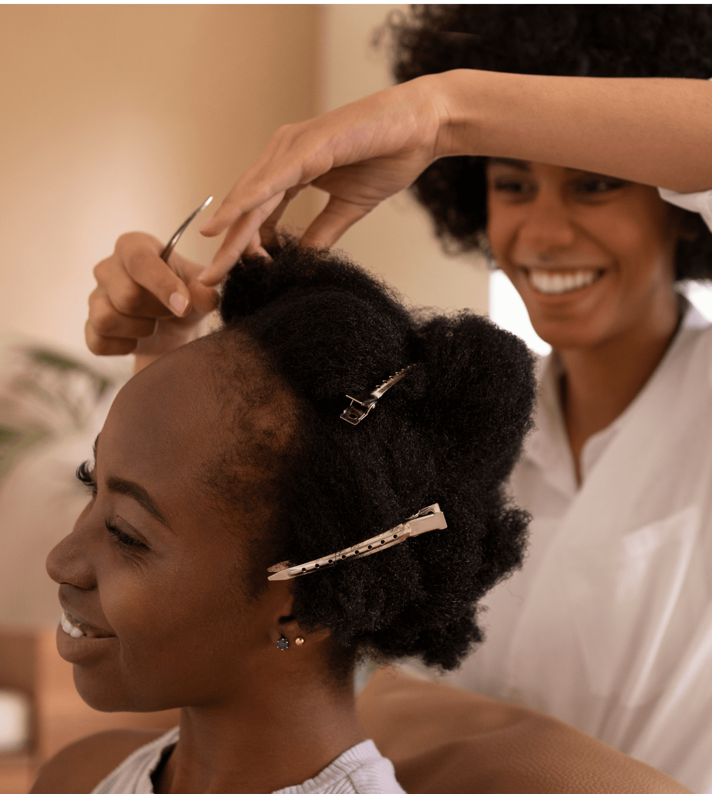 A black hairstylist cutting a woman's hair in a salon.