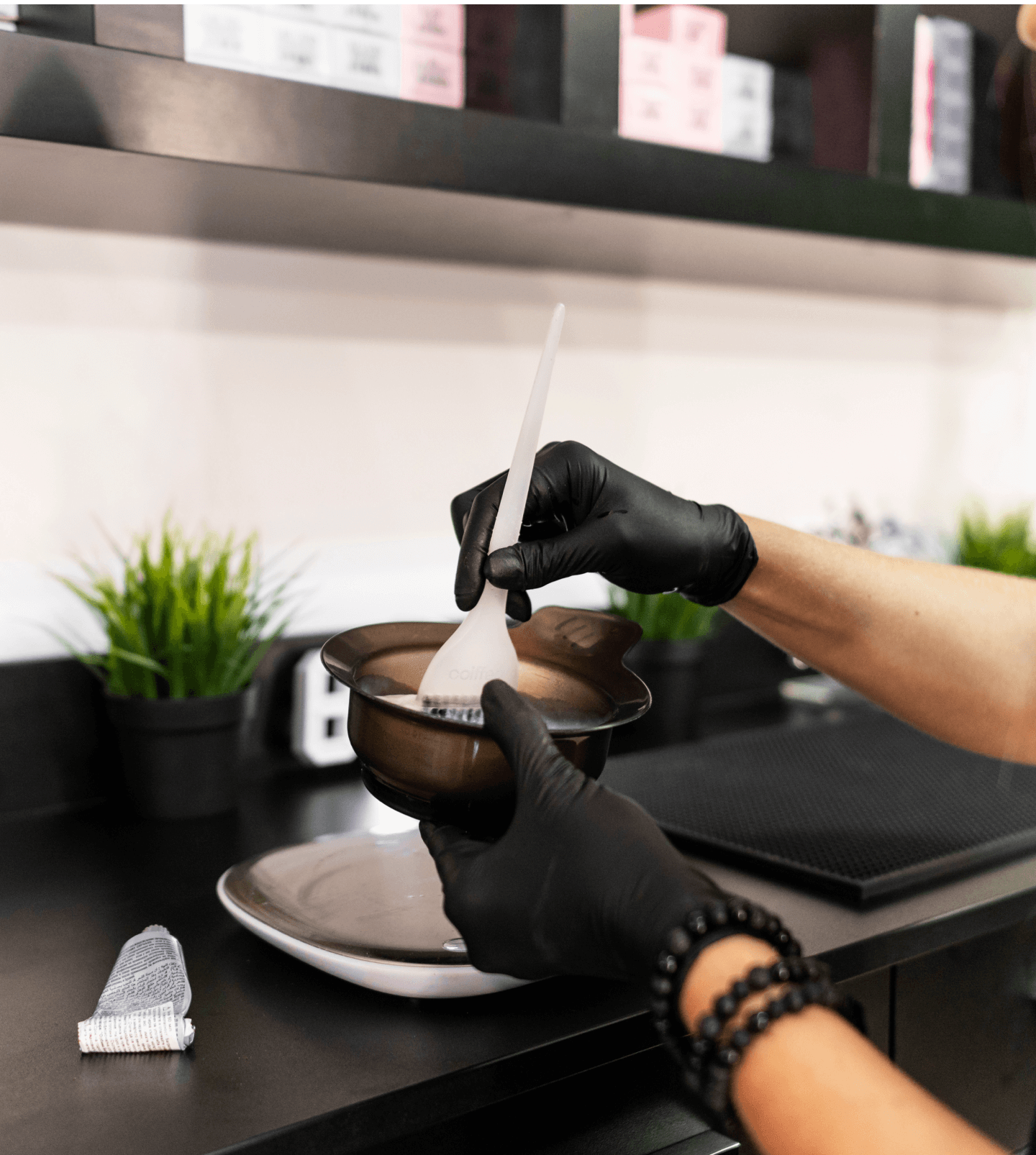 A woman with black gloves is preparing food in a kitchen.