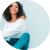 A black hairstylist with curly hair sitting on the floor.